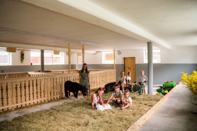 Kinder beim Entdecken und Mithelfen auf dem Kinderbauernhof am Linharterhof in der Steiermark