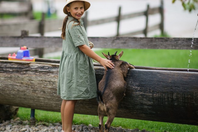 Kinder gehen mit Ziegen, Ponys spazieren