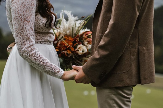 Hochzeitspaar hält sich an den Händen beim Romantikurlaub im Almchalet