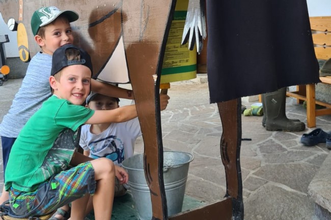 Die Kinder haben einen riesen Spaß beim Kühe melken