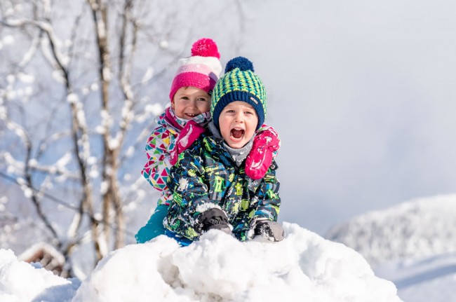 Die Kinder spielen im Schnee